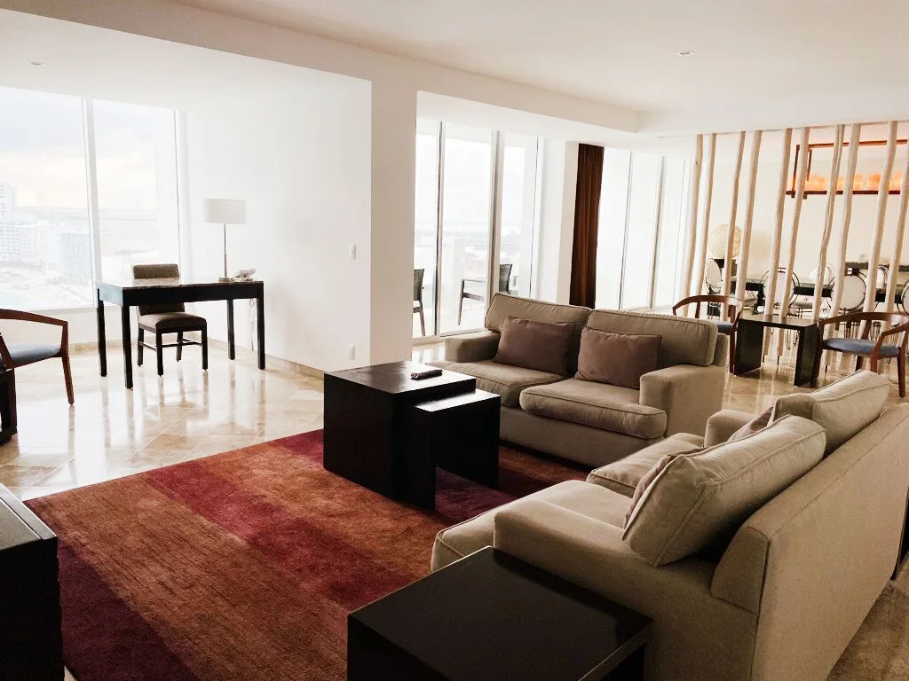 Presidential Room Ocean View living and dining area with balcony doors at Krystal Grand Cancun.