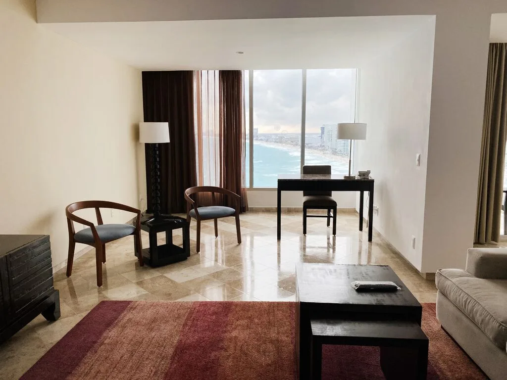 Presidential Room Ocean View sitting area with desk by windows at Krystal Grand Cancun.