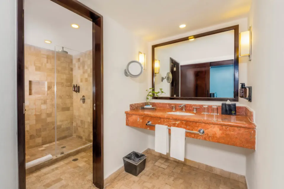 Standard Room bathroom vanity and shower at Krystal Grand Cancun.