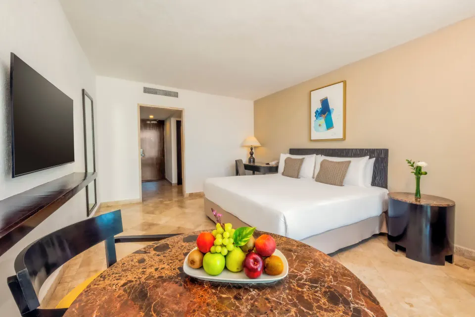 Standard Room with king bed and dining table at Krystal Grand Cancun.