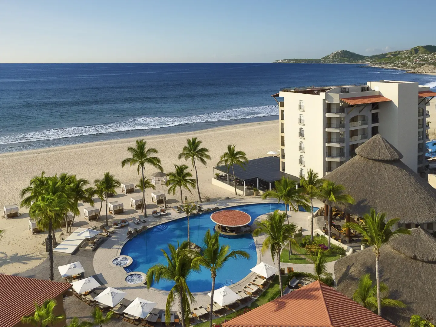 Beachfront pool, palms, and ocean at Krystal Grand Los Cabos.