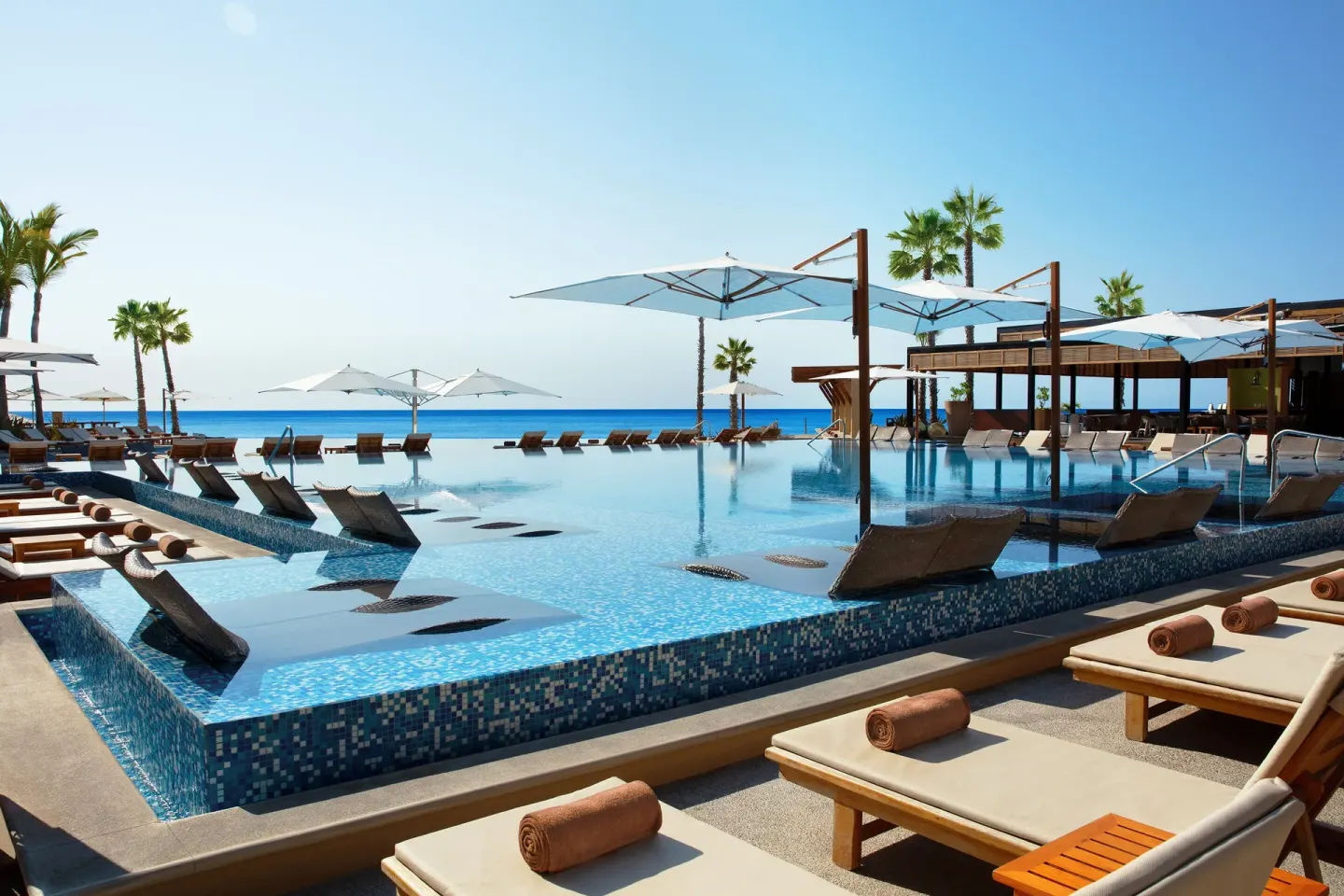 Infinity pool with loungers and ocean horizon at Krystal Grand Los Cabos.