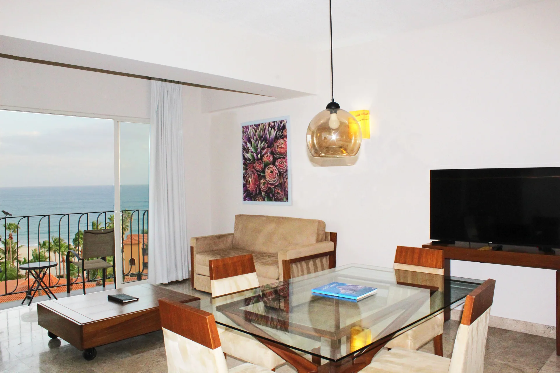 Suite living and dining area with ocean balcony at Krystal Grand Los Cabos.