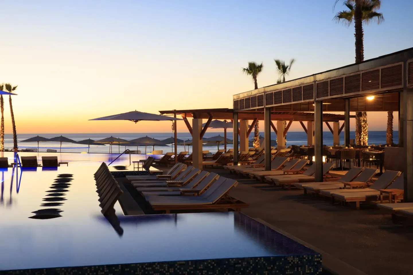 Sunset over the infinity pool and ocean at Krystal Grand Los Cabos.