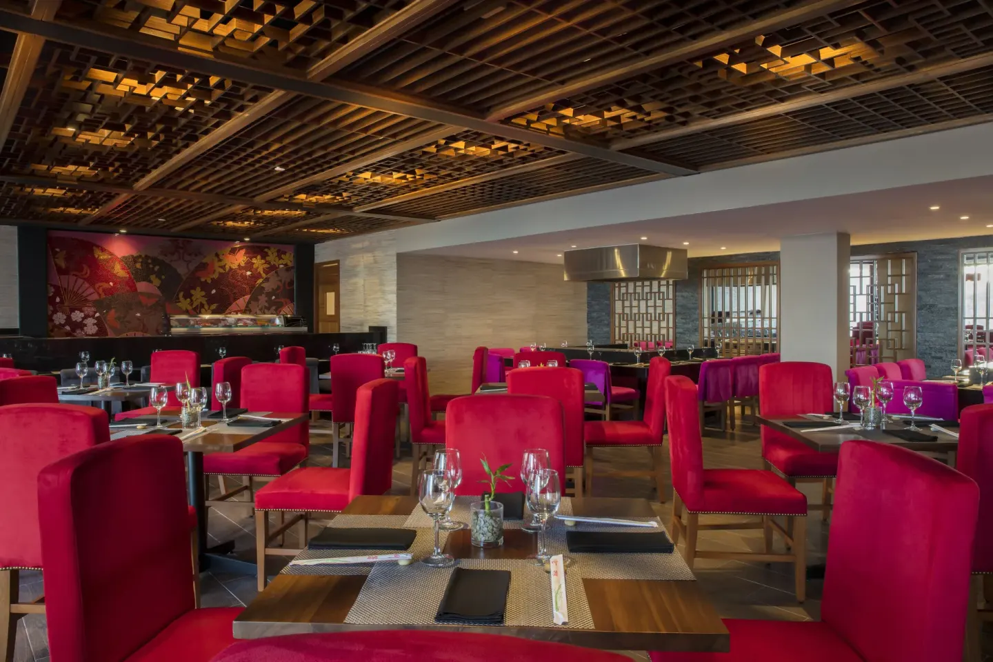 Restaurant dining room with red chairs and set tables at Krystal Grand Los Cabos.