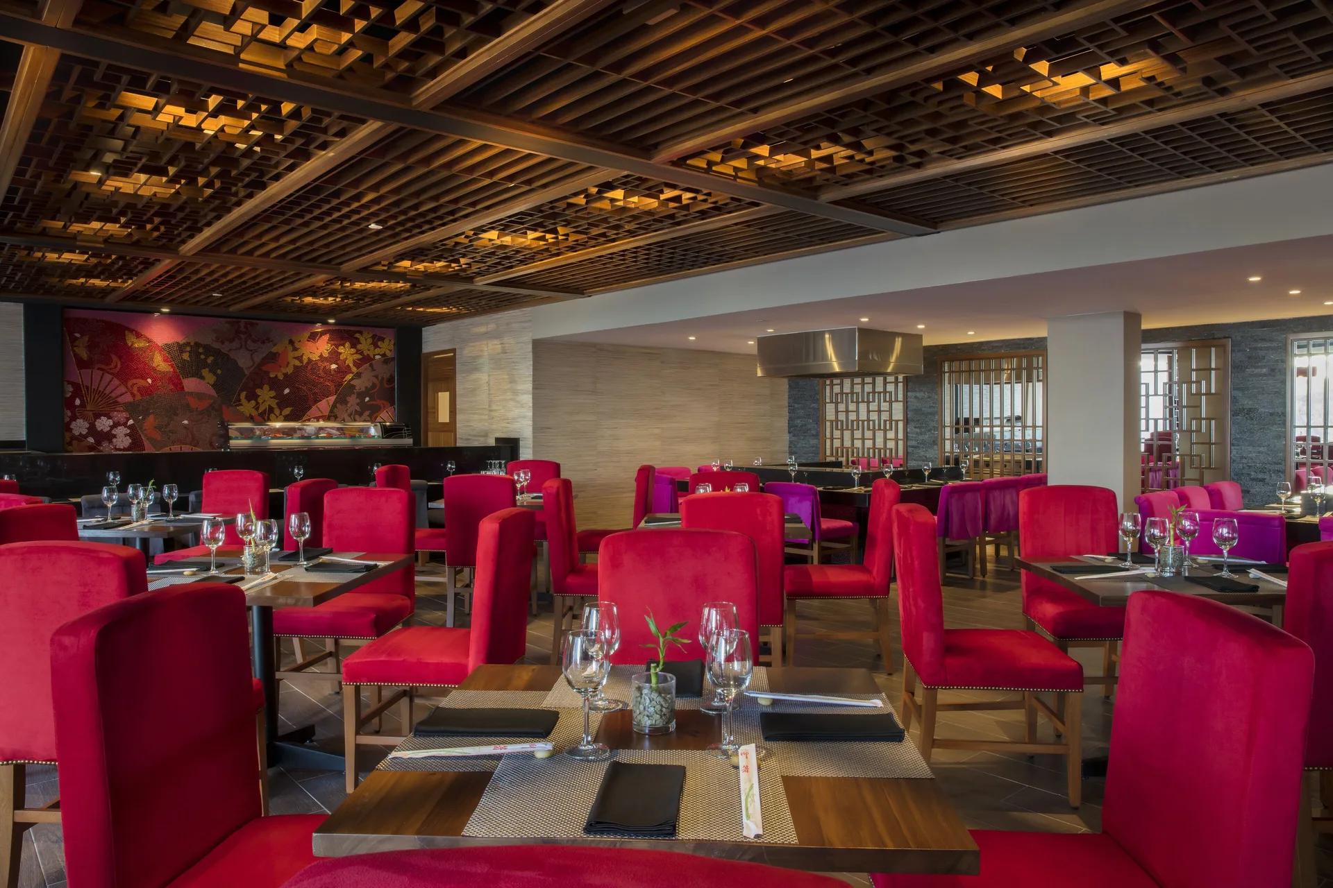 Restaurant dining room with red chairs and set tables at Krystal Grand Los Cabos.