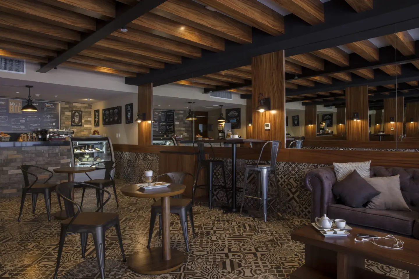 Cafe seating area with display case and lounge chairs at Krystal Grand Los Cabos.