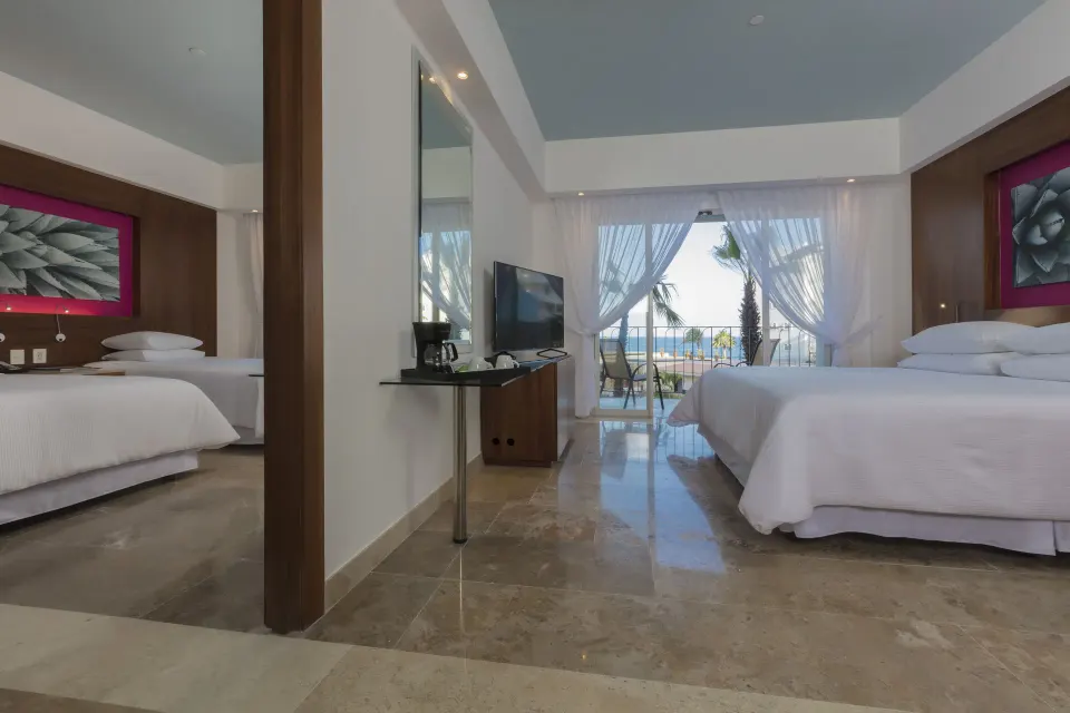 Altitude Governor Suite ocean-view bedroom with balcony doors at Krystal Grand Los Cabos.