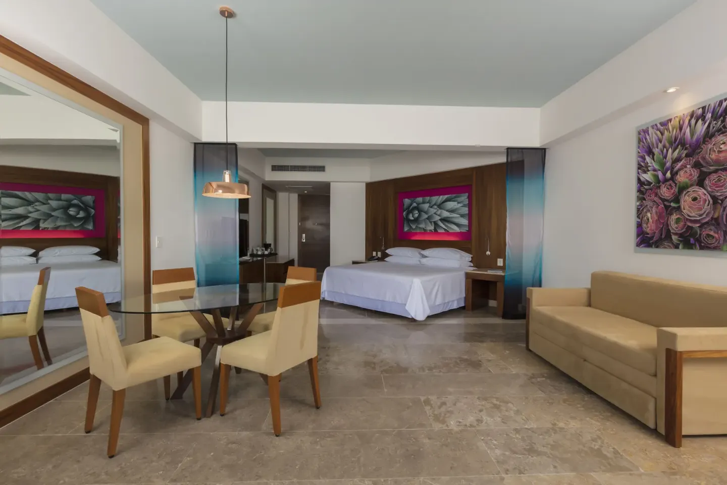 Altitude Governor Suite ocean-view king bed, dining table, and sofa at Krystal Grand Los Cabos.