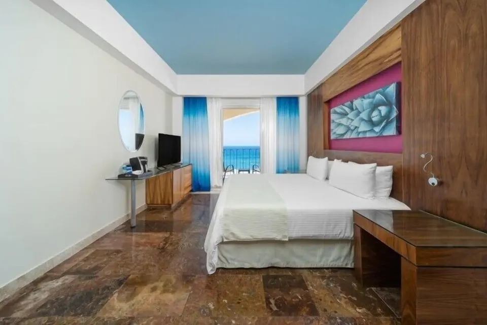 Altitude Junior Suite Ocean Front king bed and balcony view at Krystal Grand Los Cabos.