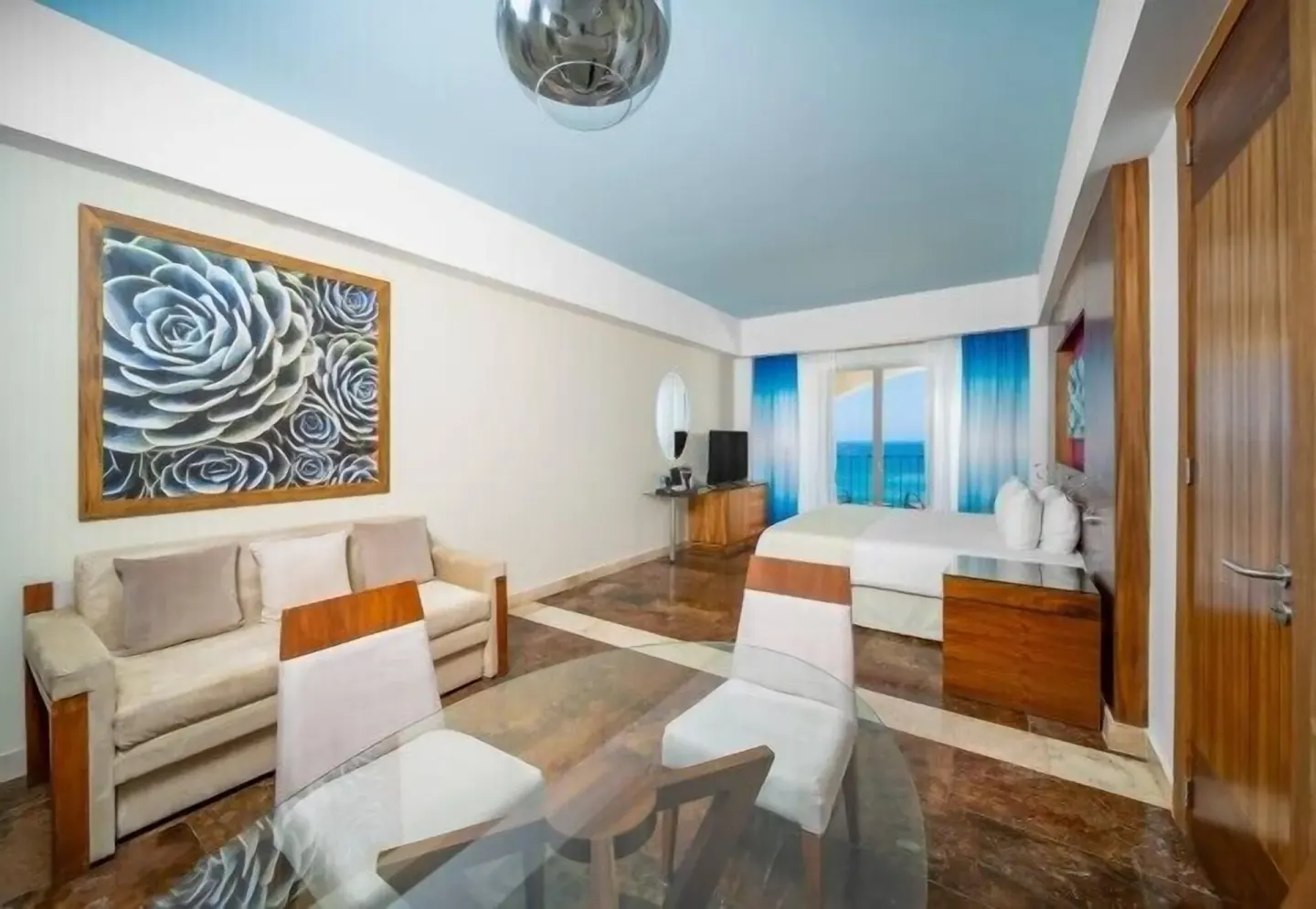 Altitude Junior Suite Ocean Front seating and king bed at Krystal Grand Los Cabos.
