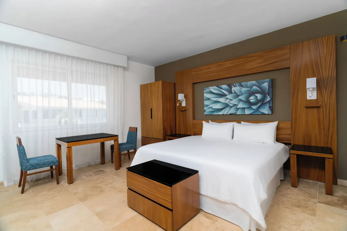Deluxe Palmilla Garden View king bed and seating area at Krystal Grand Los Cabos.