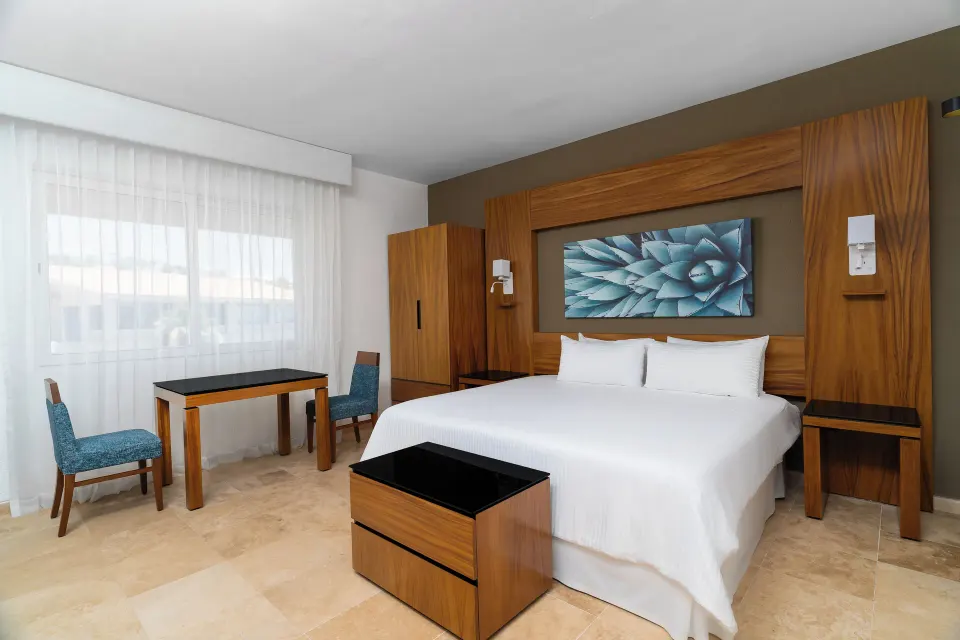 Deluxe Palmilla Garden View king bed and seating area at Krystal Grand Los Cabos.