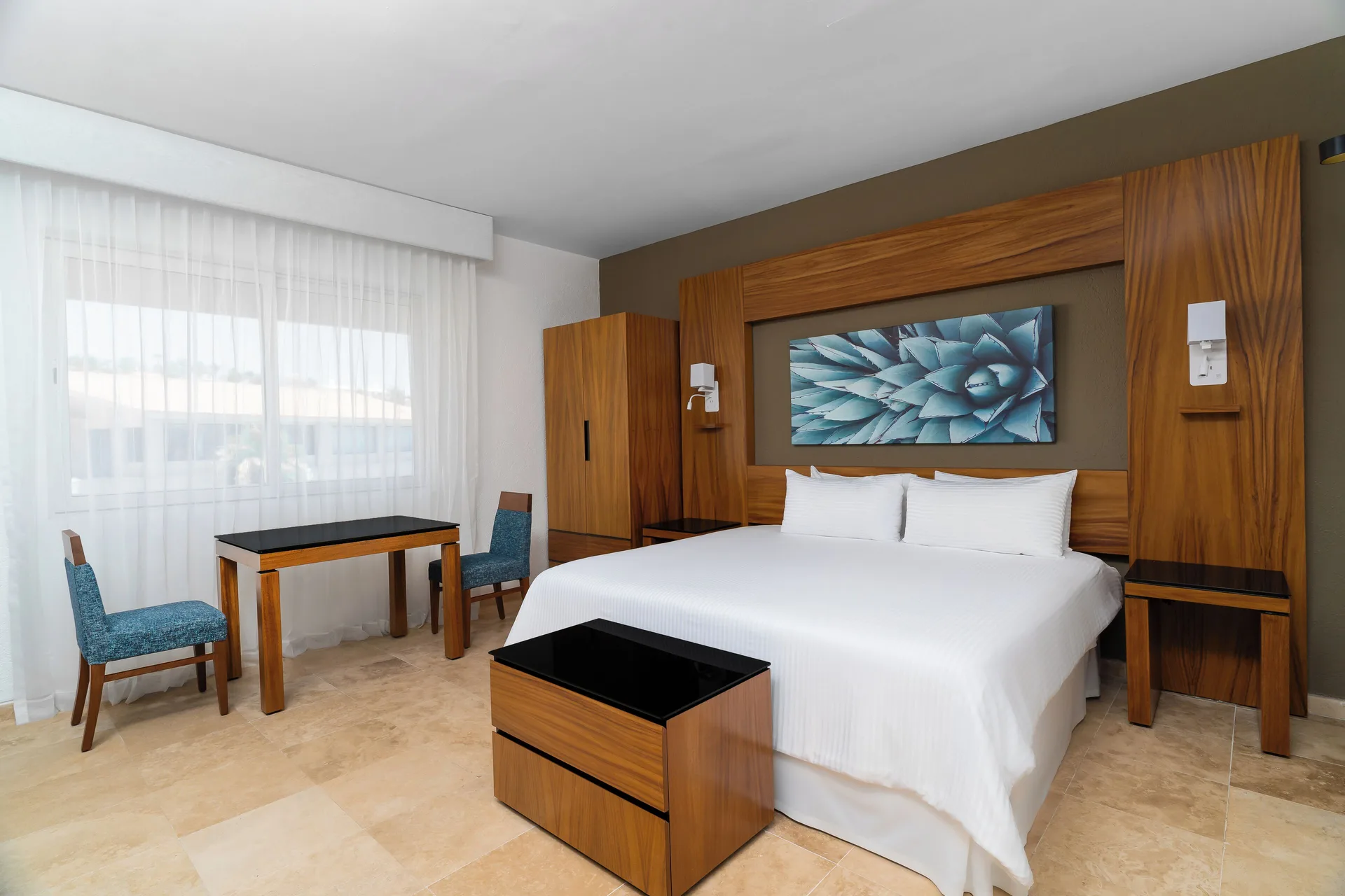 Deluxe Palmilla Garden View king bed and seating area at Krystal Grand Los Cabos.