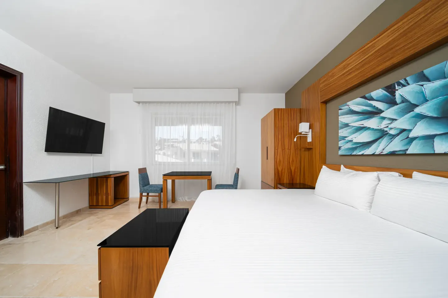 Deluxe Palmilla Garden View king room with TV and window at Krystal Grand Los Cabos.