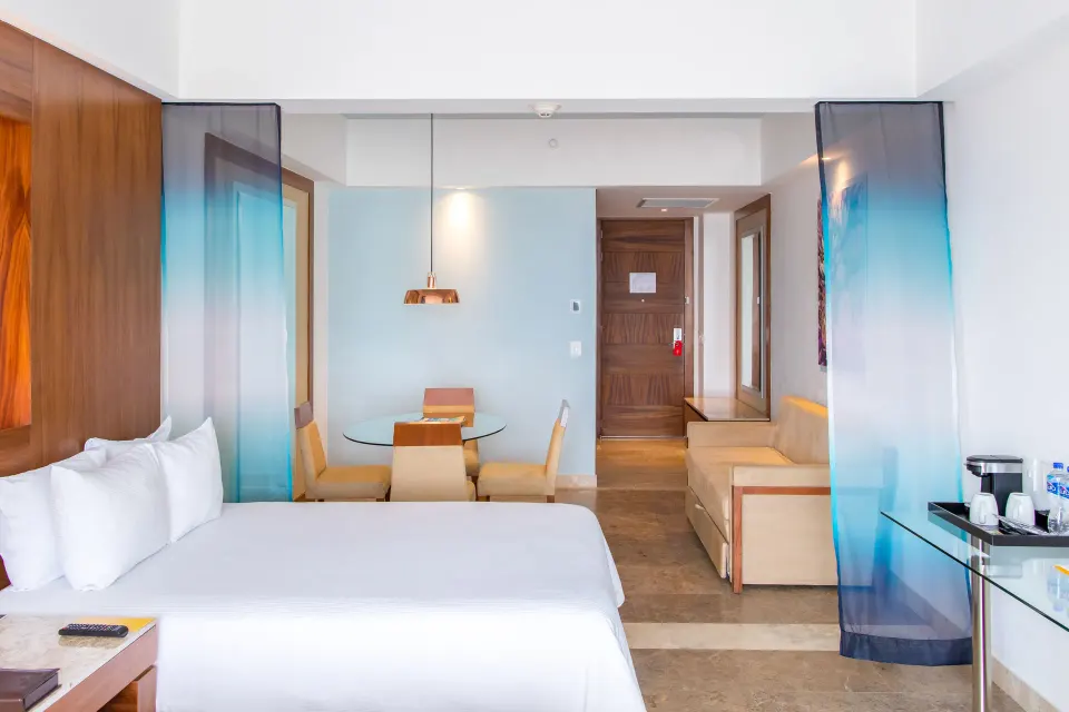 Junior Suite Ocean View king bed, dining area and sofa at Krystal Grand Los Cabos.