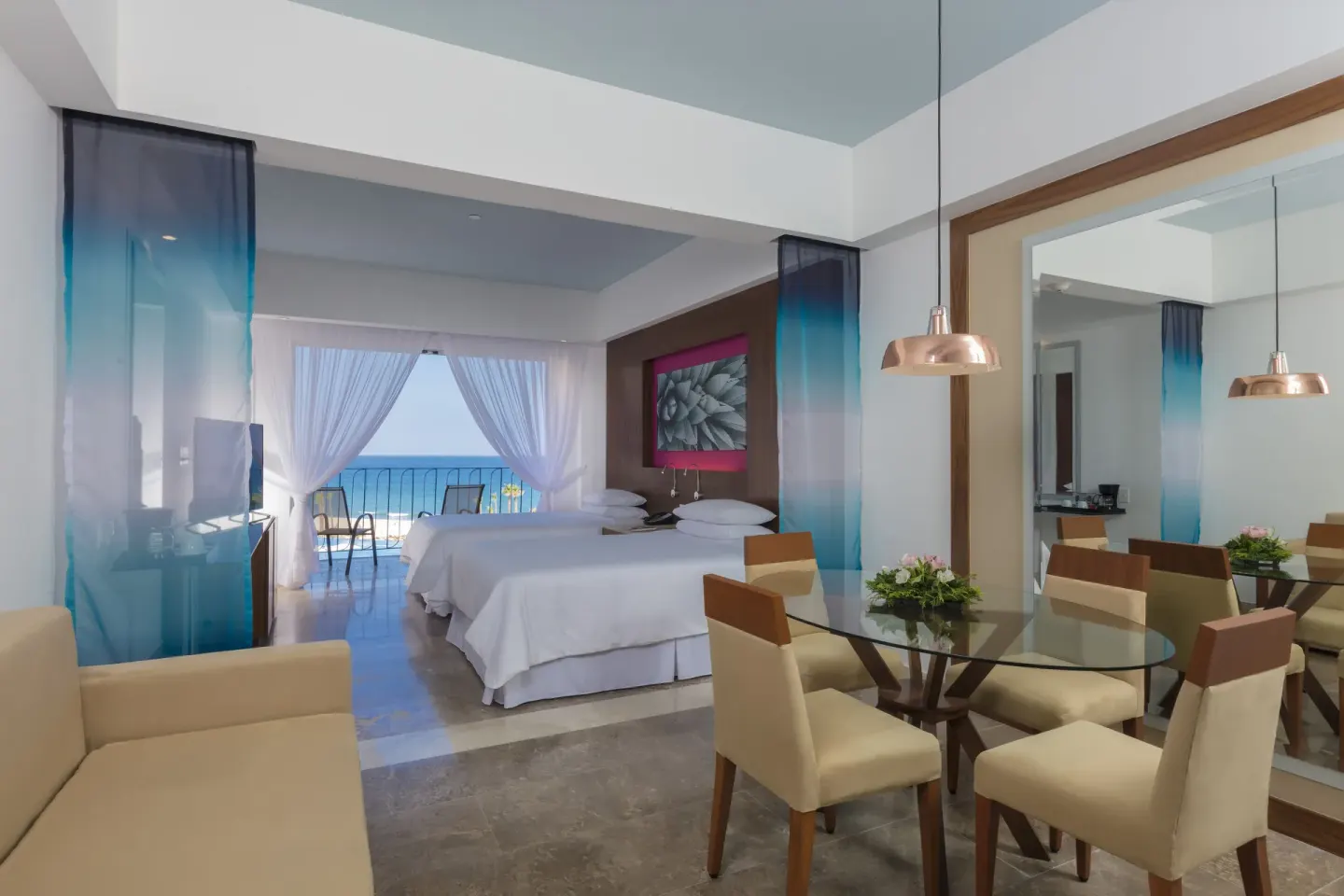 Junior Suite Ocean View with two beds, dining table and balcony at Krystal Grand Los Cabos.