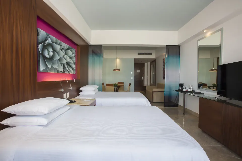 Junior Suite Ocean View with two beds and wall-mounted TV at Krystal Grand Los Cabos.