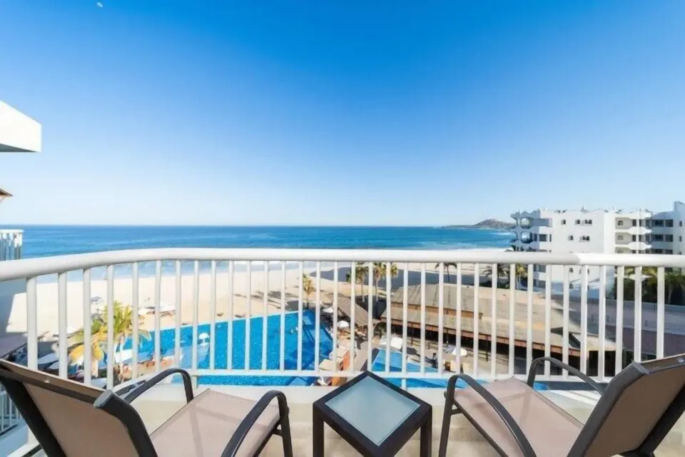 Suite Palmilla Ocean View balcony with chairs and ocean vista at Krystal Grand Los Cabos.