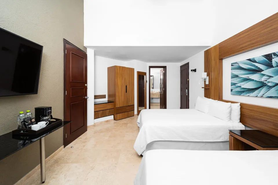 Suite Palmilla Ocean View room with two beds and refreshment counter at Krystal Grand Los Cabos.