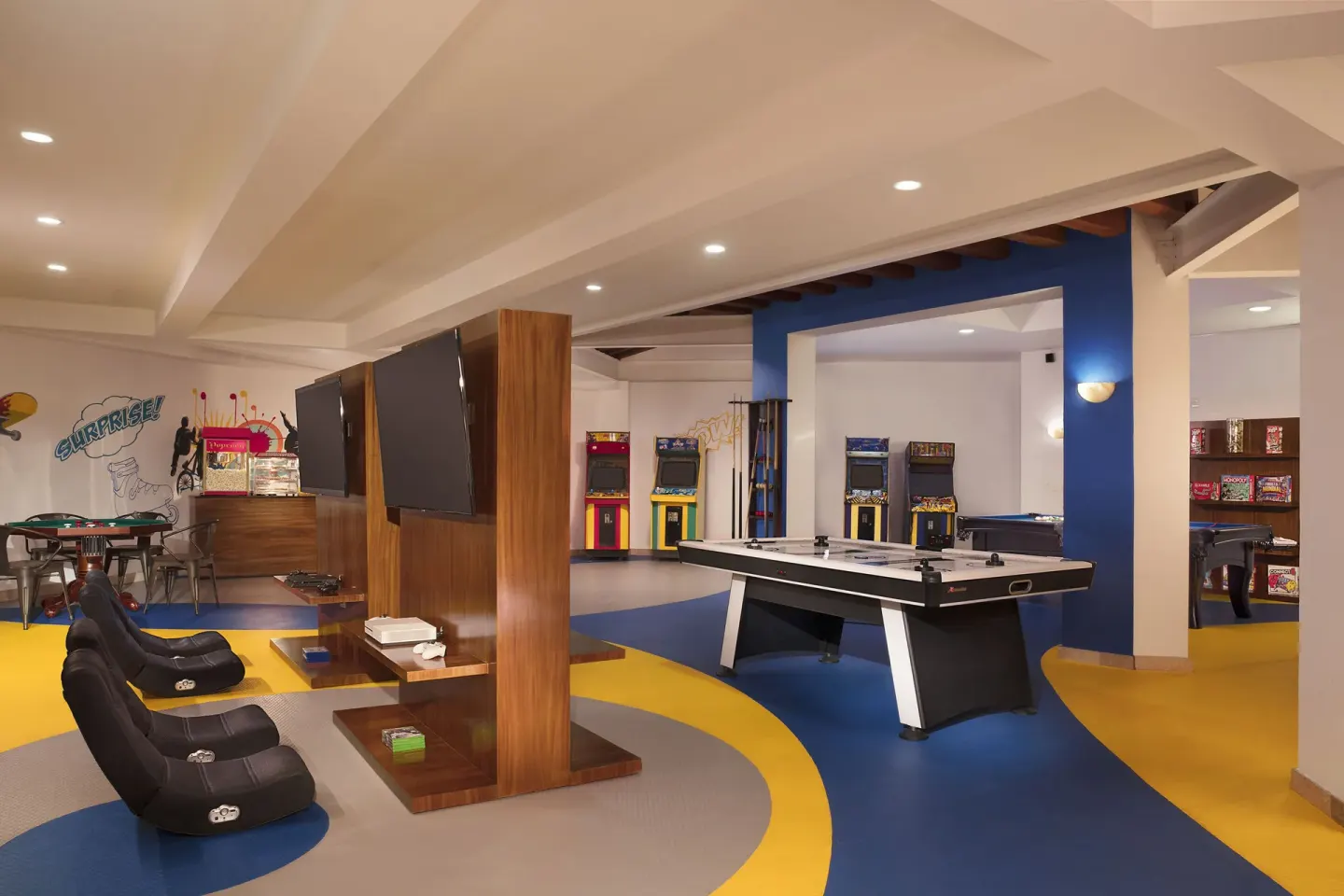 Game room with arcade machines, screens, and a pool table at Krystal Grand Nuevo Vallarta.