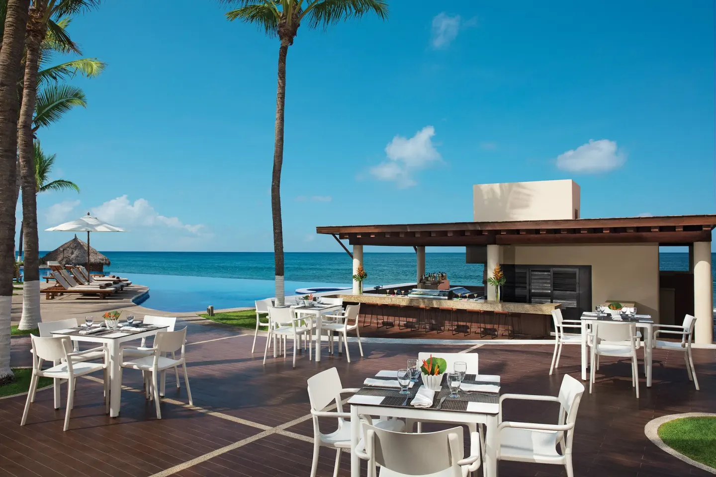 Oceanfront dining terrace and bar by the pool at Krystal Grand Nuevo Vallarta.