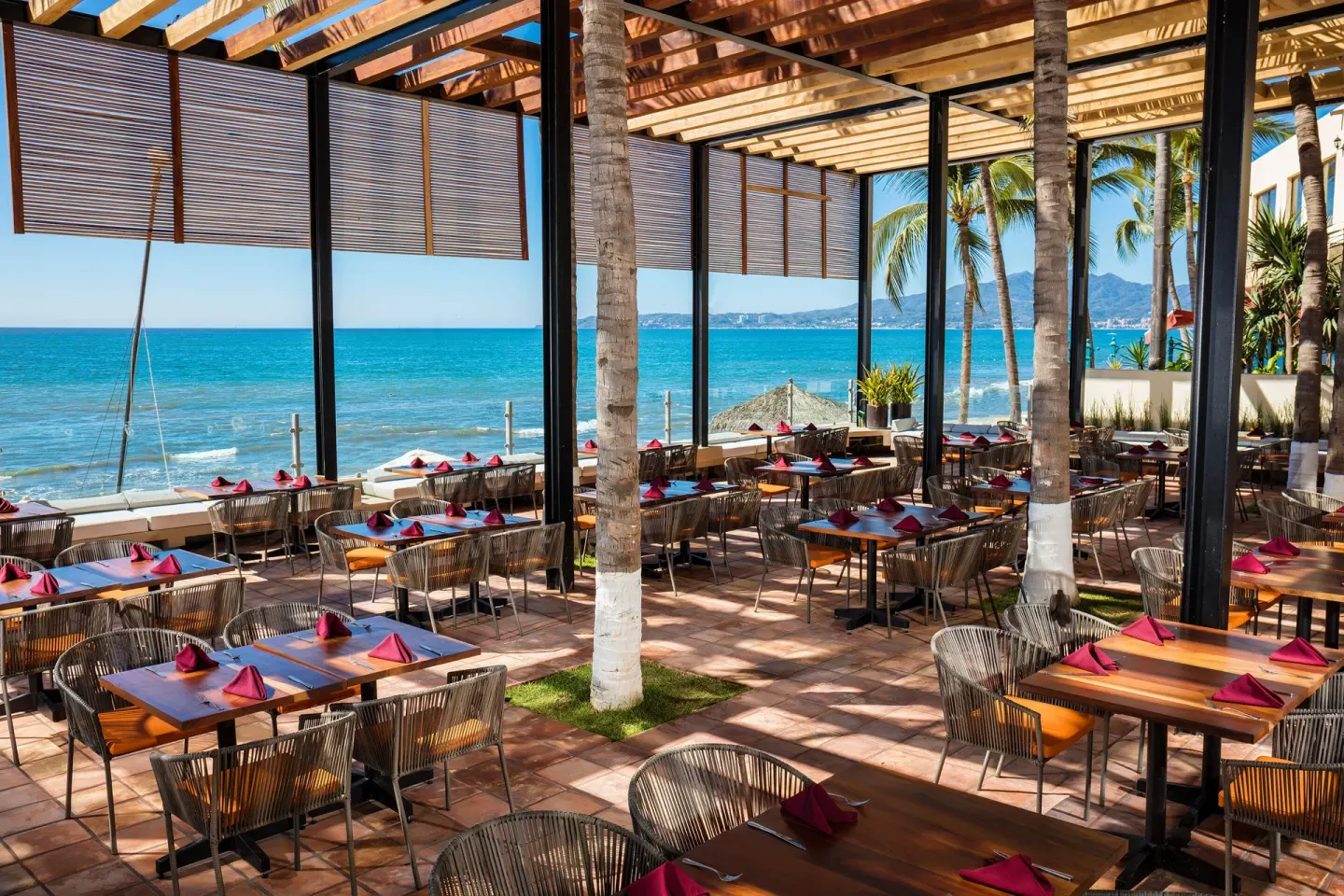 Oceanfront terrace dining with set tables at Krystal Grand Nuevo Vallarta.