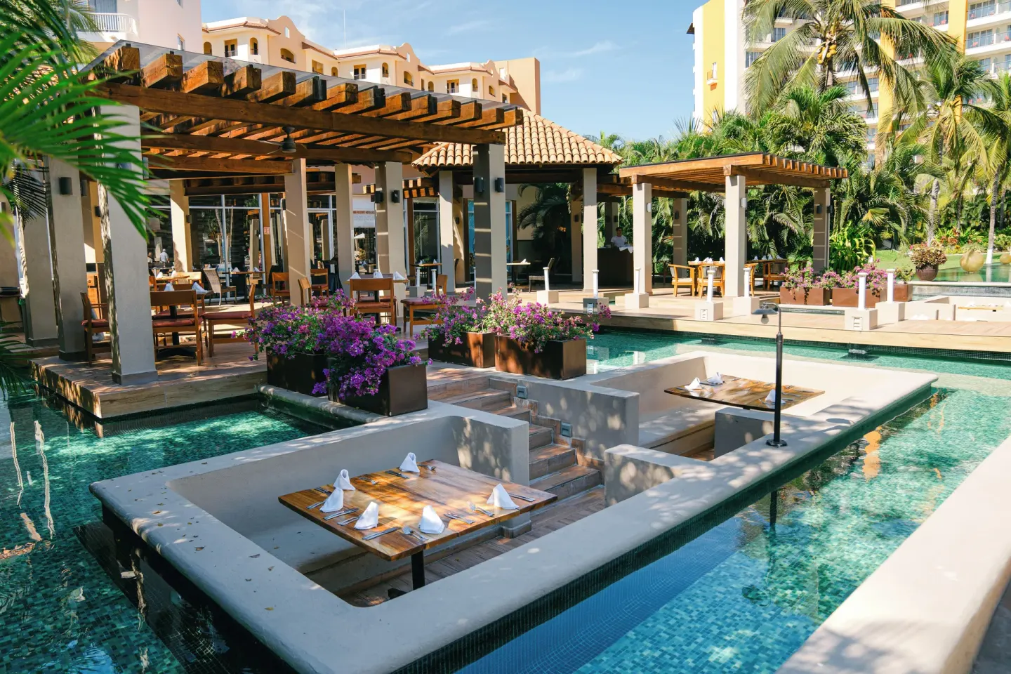 Poolside dining terraces surrounded by water at Krystal Grand Nuevo Vallarta.