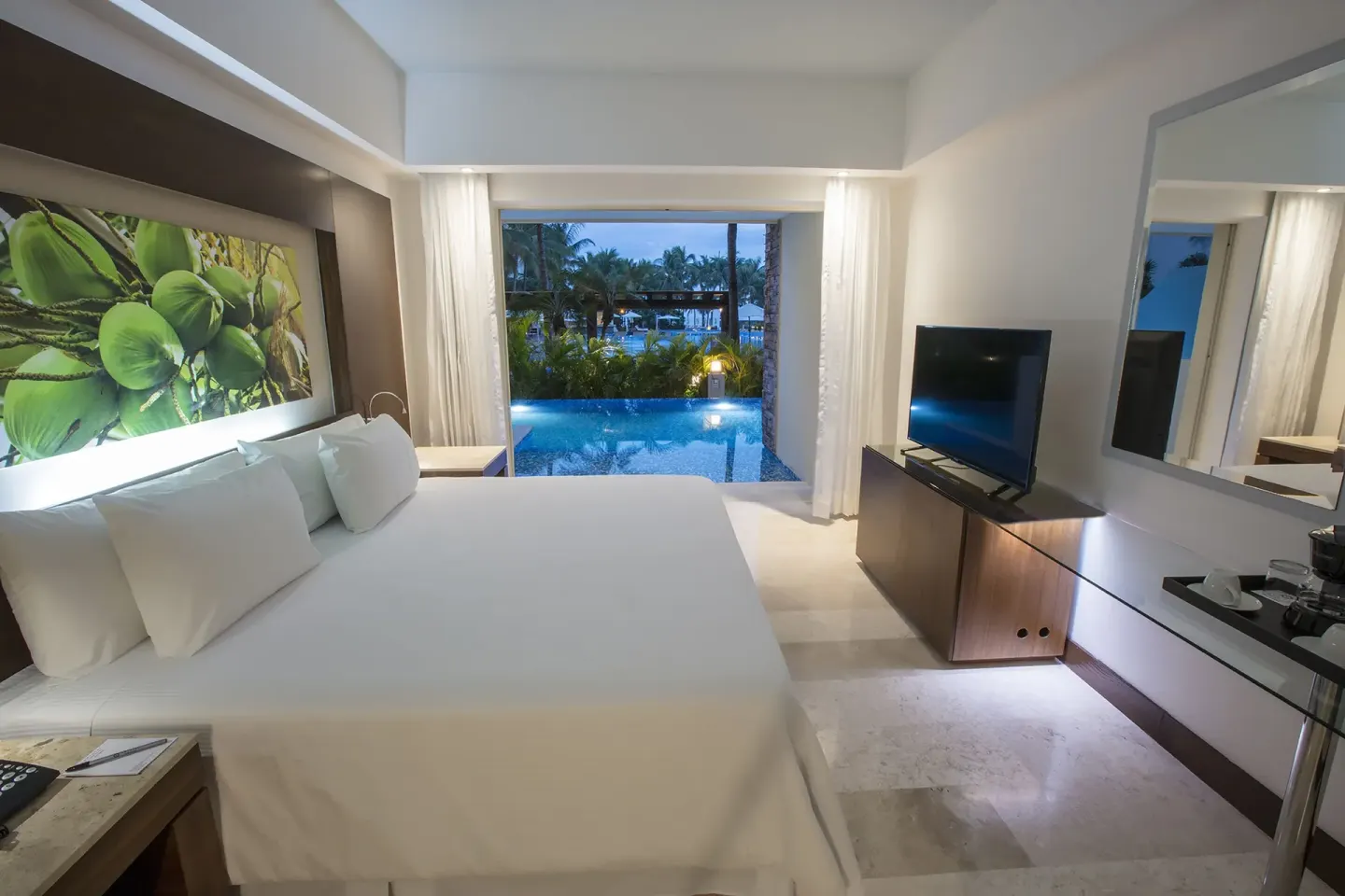 Swim-out guest room with double bed, TV and pool view at Krystal Grand Nuevo Vallarta.