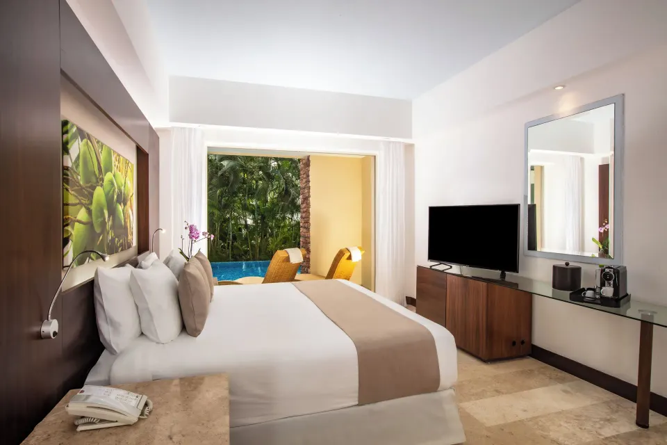 Altitude Club Junior Suite Swim Out king bed facing a terrace pool at Krystal Grand Nuevo Vallarta.