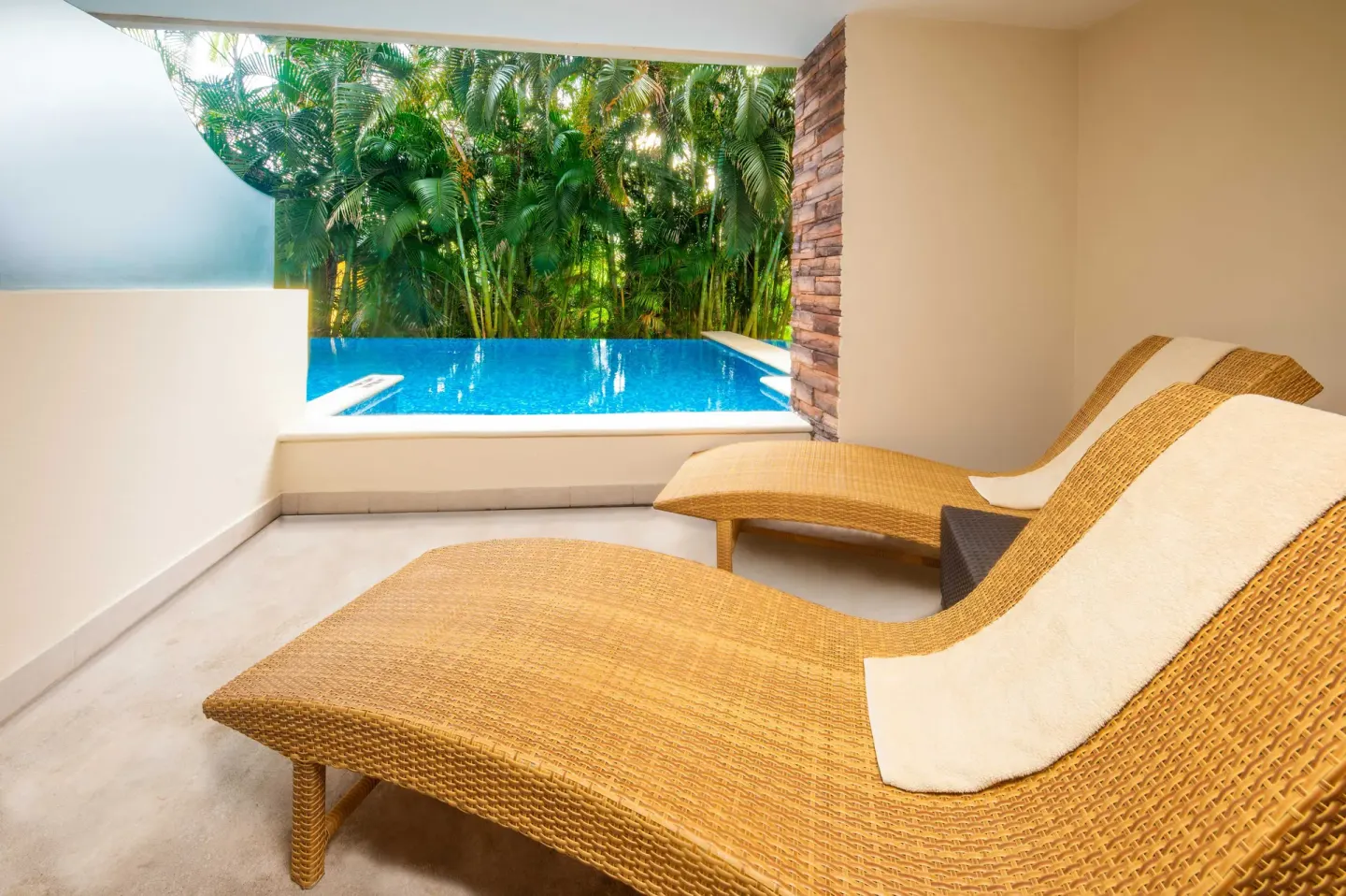 Swim-out terrace with two wicker loungers and pool at Krystal Grand Nuevo Vallarta.