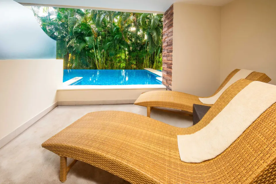 Swim-out terrace with two wicker loungers and pool at Krystal Grand Nuevo Vallarta.