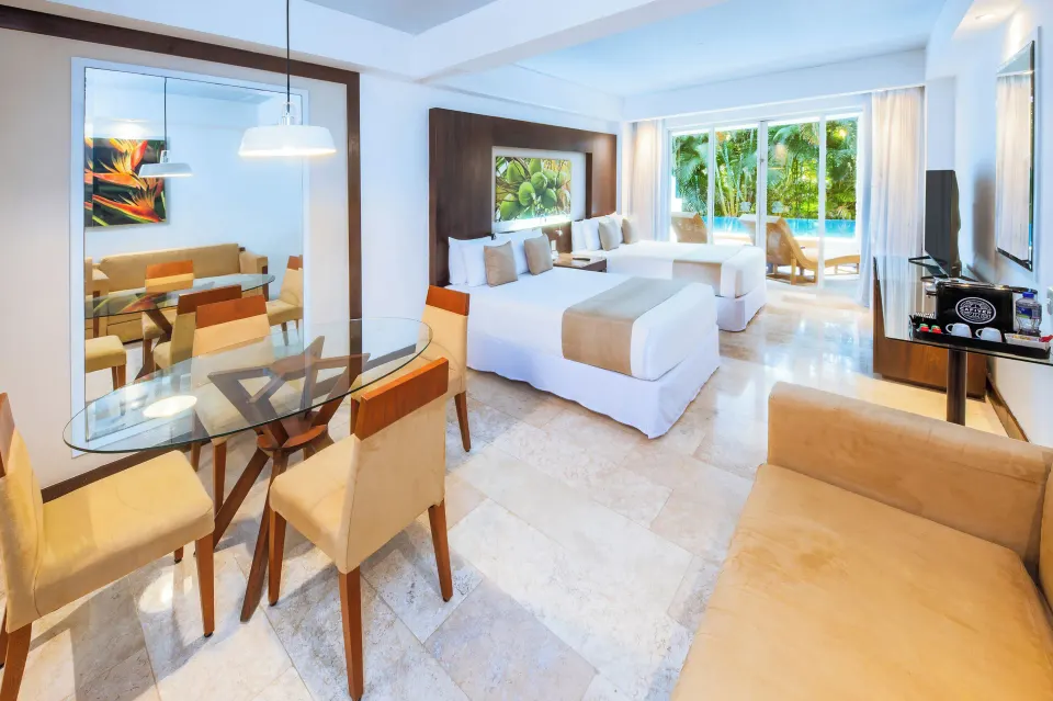 Altitude Club Junior Suite Swim Out with two beds, dining table and sofa at Krystal Grand Nuevo Vallarta.