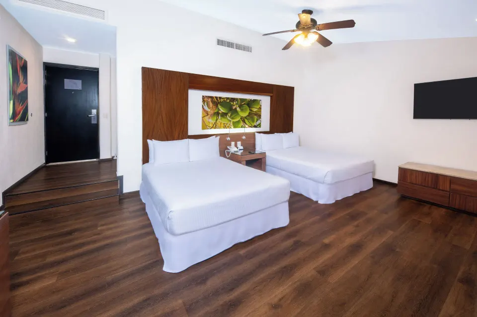 Deluxe Room Ocean View with two beds and wall-mounted TV at Krystal Grand Nuevo Vallarta.
