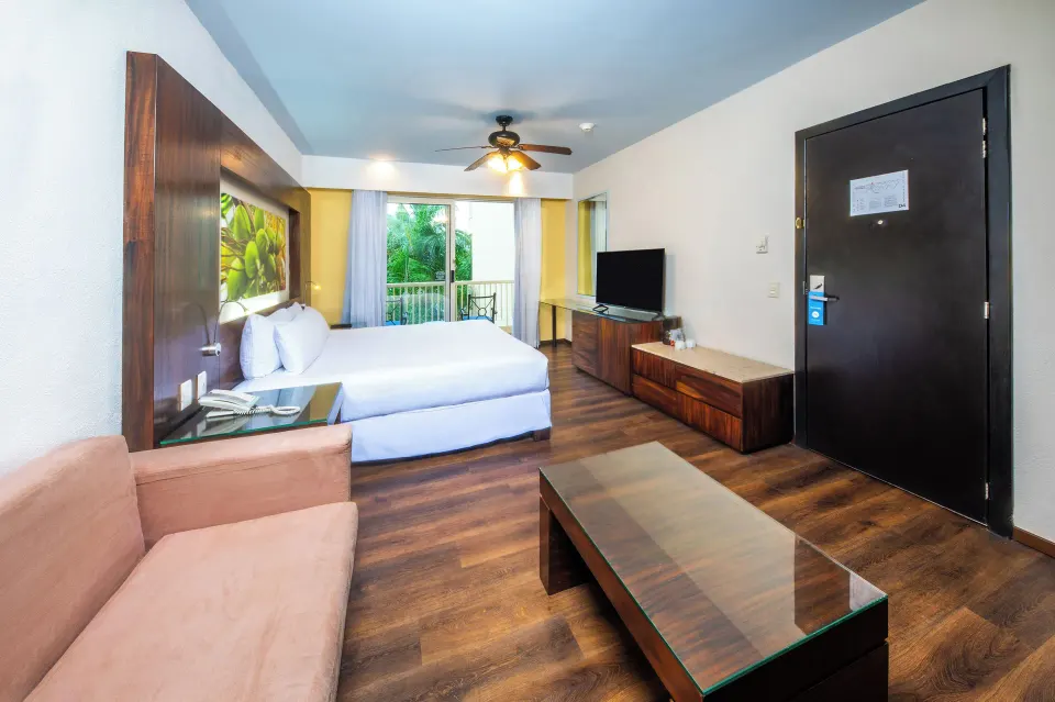 Deluxe Tropical Room View with king bed, sofa, and TV at Krystal Grand Nuevo Vallarta.