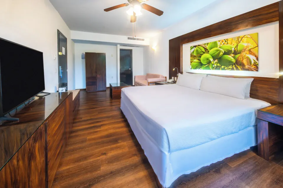 Deluxe Tropical Room View king bed with TV and seating at Krystal Grand Nuevo Vallarta.