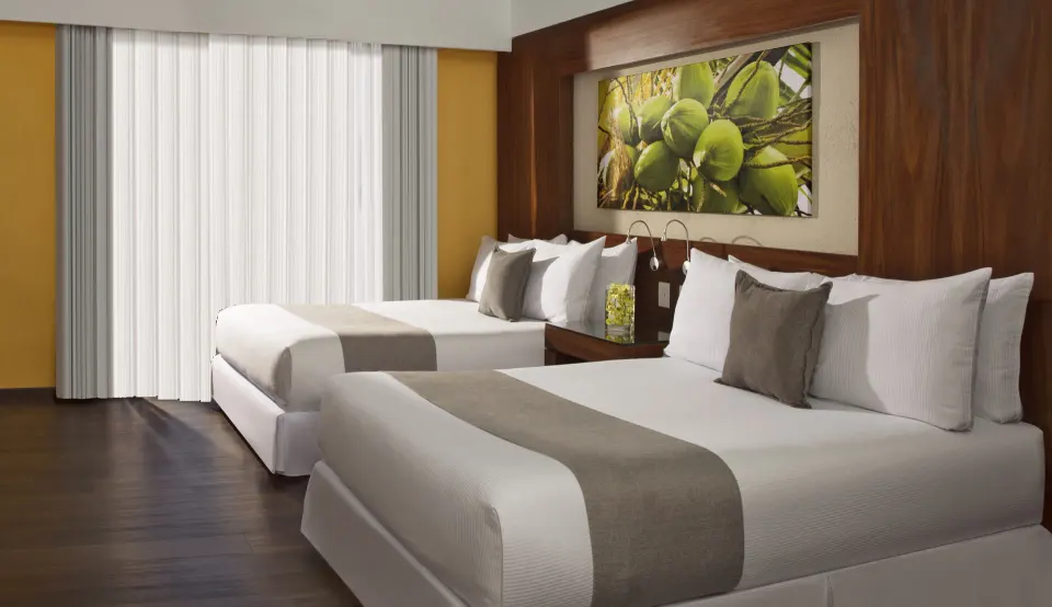 Deluxe Tropical View Doble with two beds and bright curtains at Krystal Grand Nuevo Vallarta.