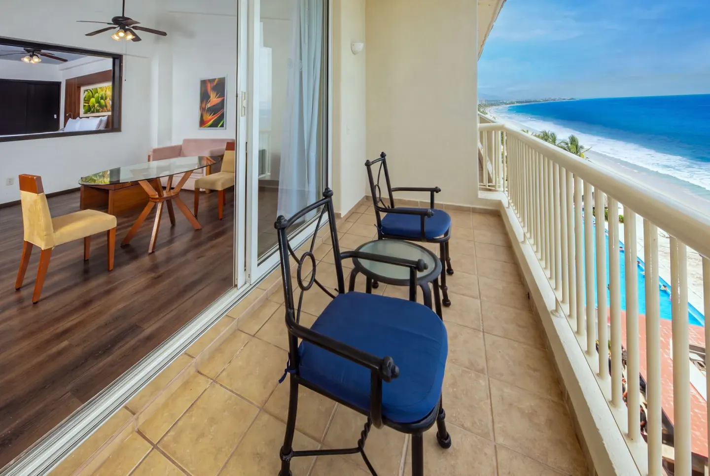 Junior Suite Ocean View balcony with blue-cushioned chairs at Krystal Grand Nuevo Vallarta.