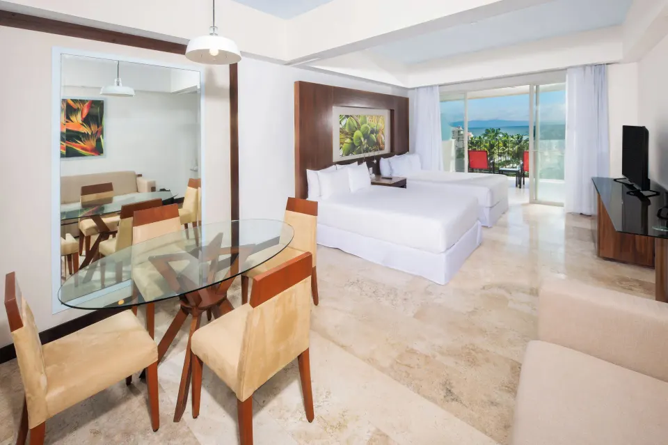 Junior Suite Ocean View with king bed and dining table at Krystal Grand Nuevo Vallarta.