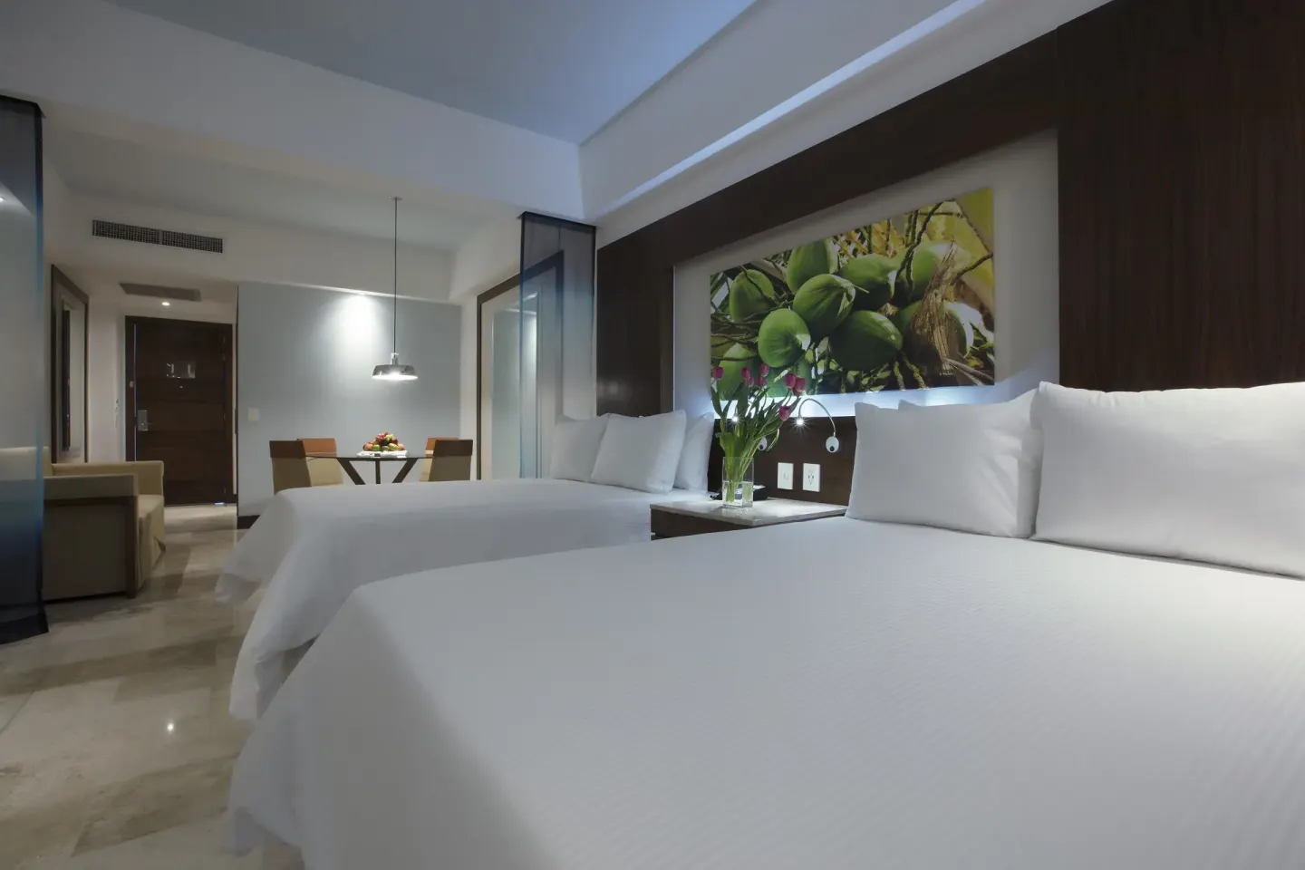 Junior Suite Pool View Doble with two white beds and tropical wall art at Krystal Grand Nuevo Vallarta.