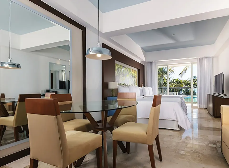 Junior Suite Pool View with dining table, two beds, and balcony at Krystal Grand Nuevo Vallarta.