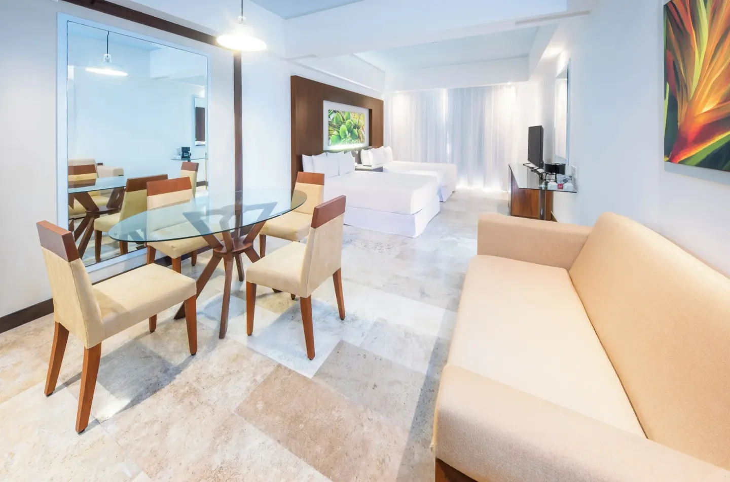 Junior Suite Pool View with sofa, dining table, and two beds at Krystal Grand Nuevo Vallarta.