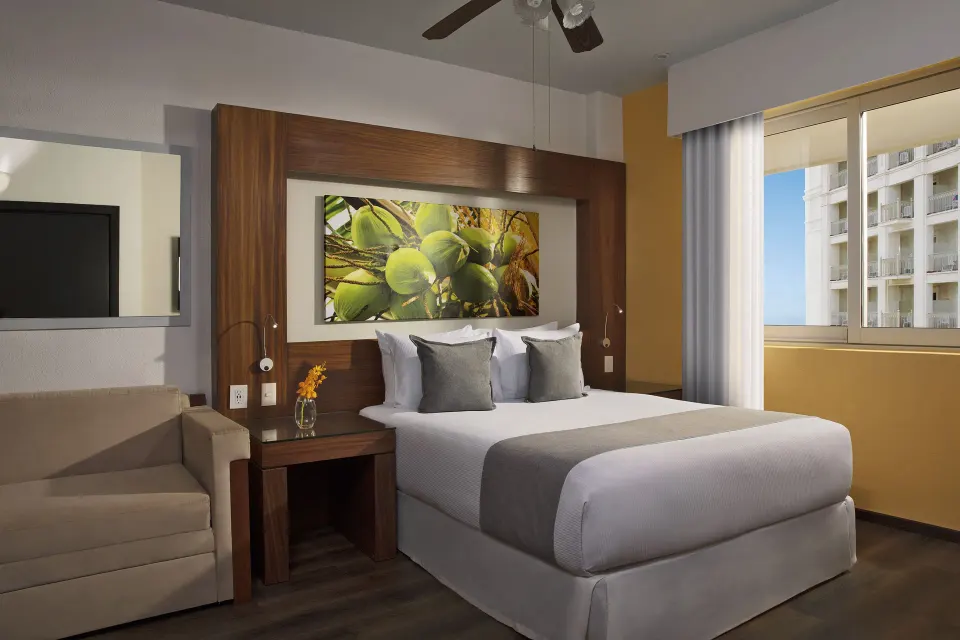 Standard room with king bed and sofa at Krystal Grand Nuevo Vallarta.