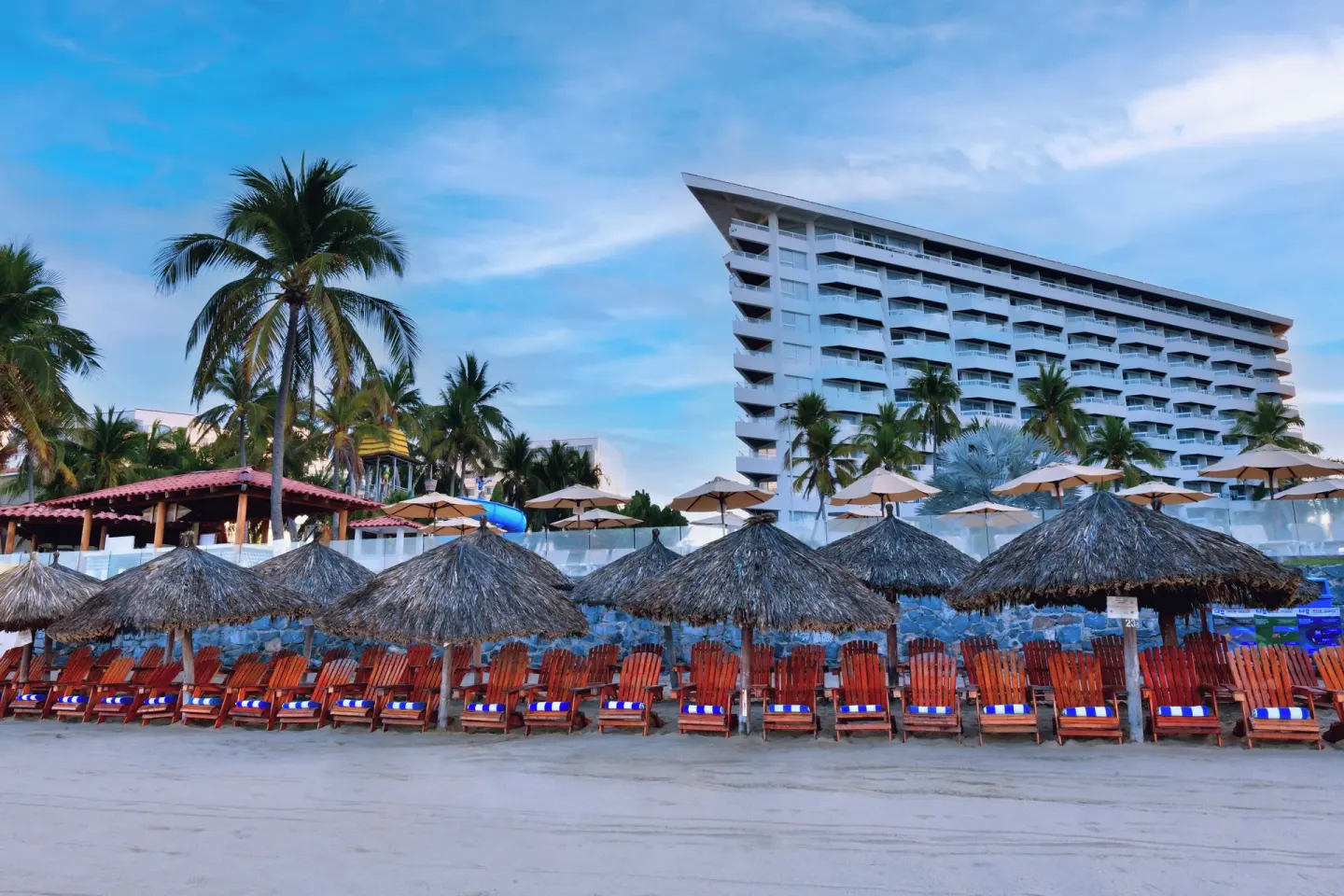 Beach palapas and lounge chairs line the sand in front of Krystal Ixtapa.
