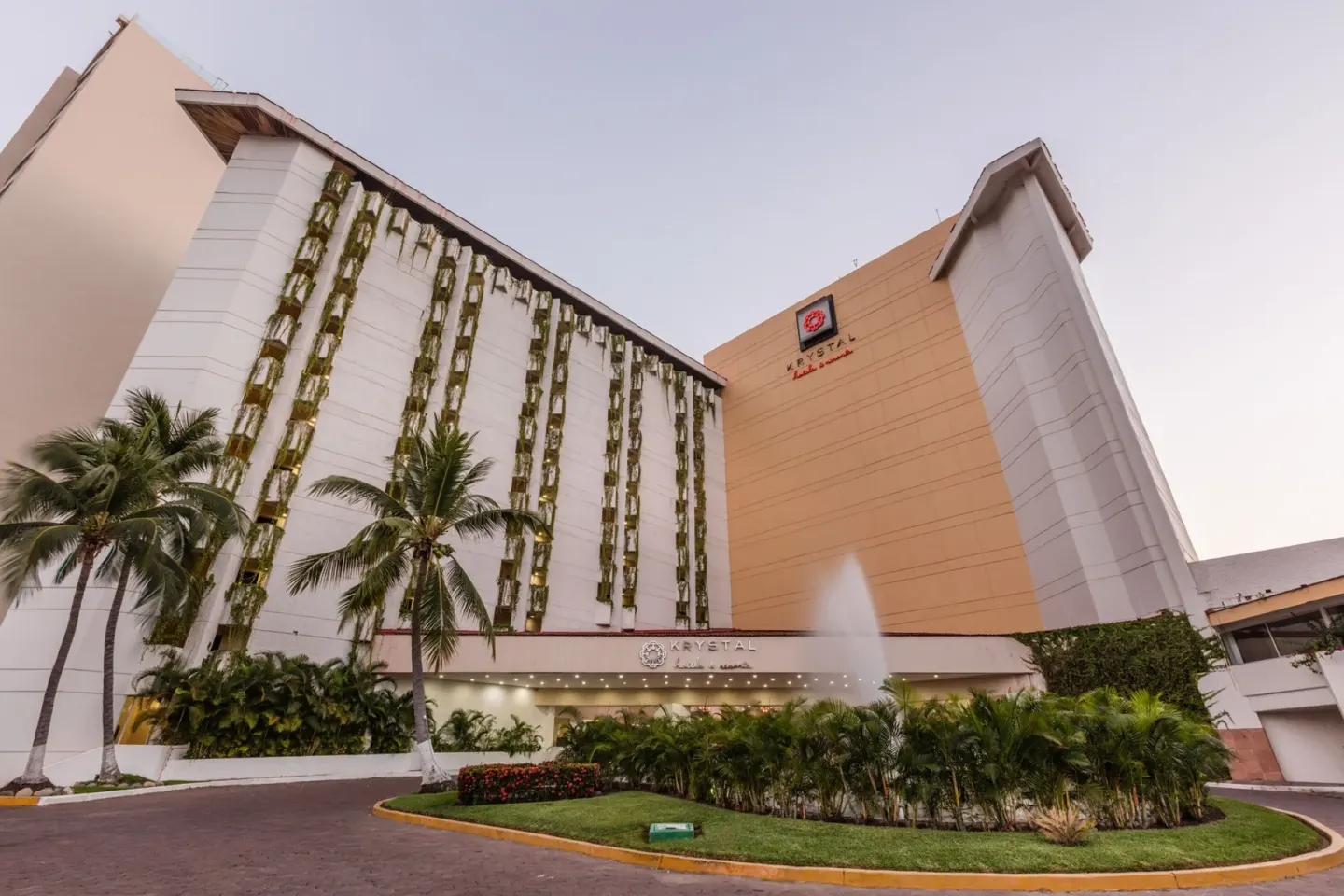 Main entrance exterior with fountain and palms at Krystal Ixtapa.