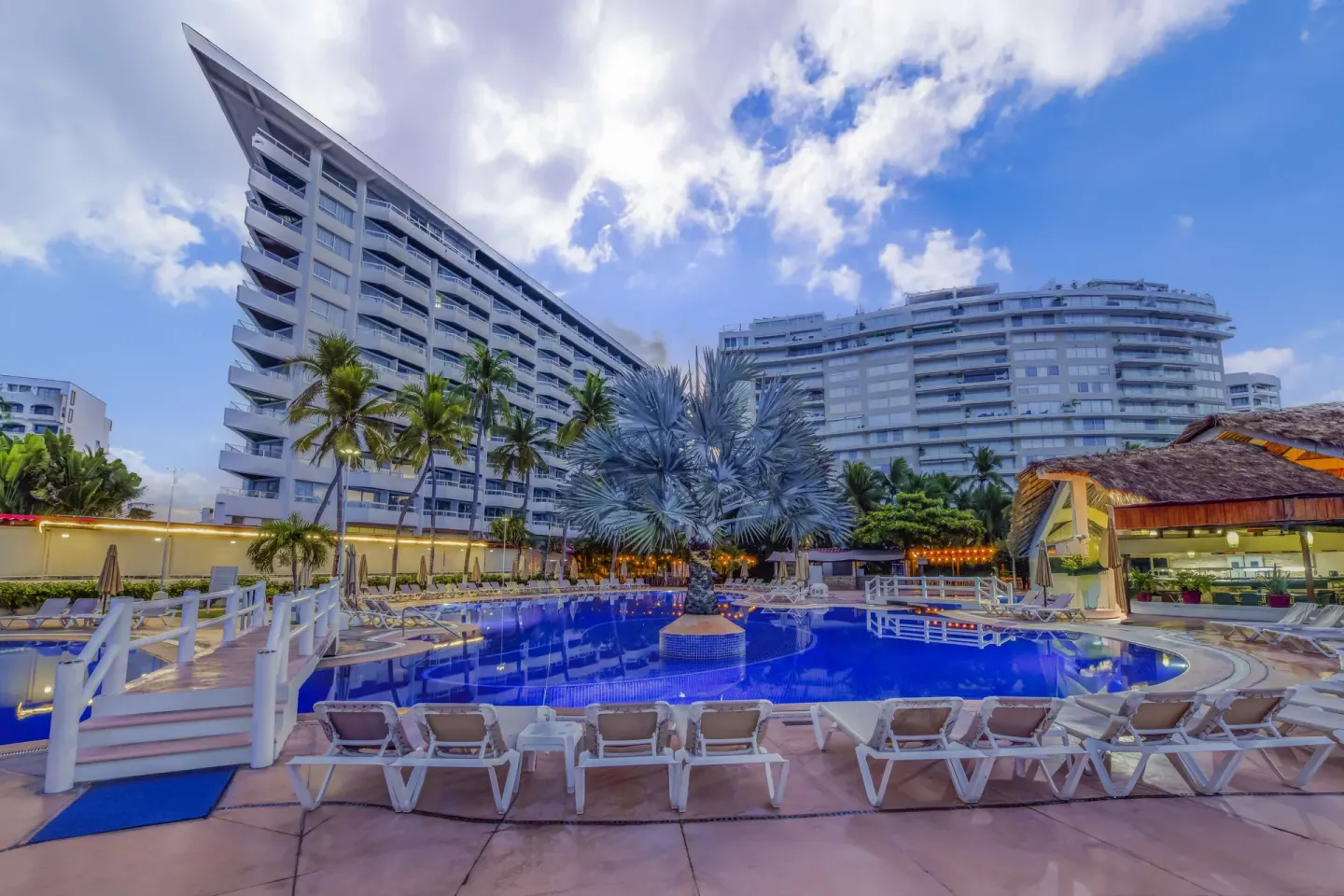 Main pool with lounge chairs and resort towers at Krystal Ixtapa.