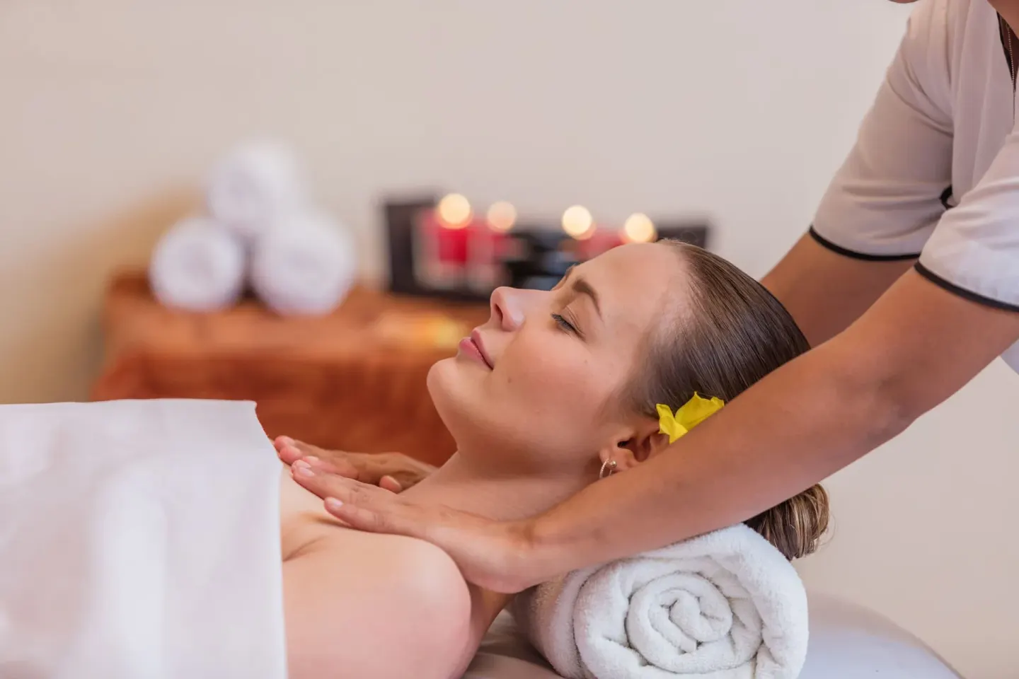 Spa treatment with a guest receiving a massage beside candles and towels at Krystal Ixtapa.