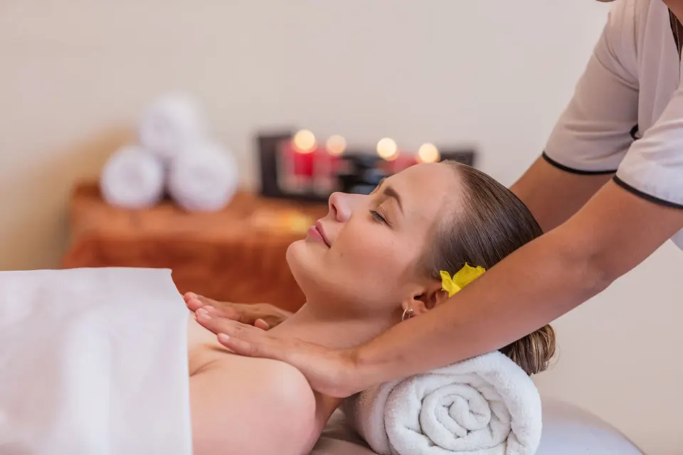 Spa treatment with a guest receiving a massage beside candles and towels at Krystal Ixtapa.