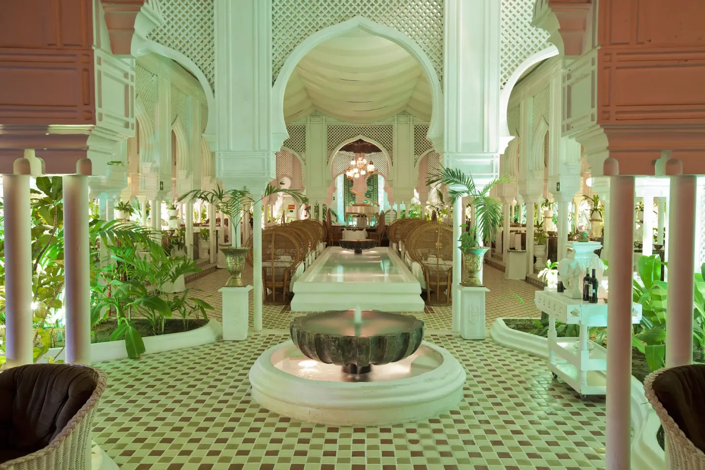 An ornate white dining room with arches and a central fountain at Krystal Ixtapa.