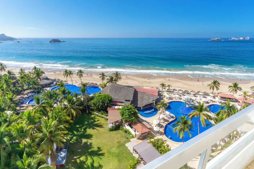 Ocean View room balcony overlooking pools, gardens, beach, and ocean at Krystal Ixtapa.